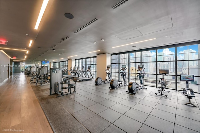 exercise room with floor to ceiling windows and light hardwood / wood-style flooring