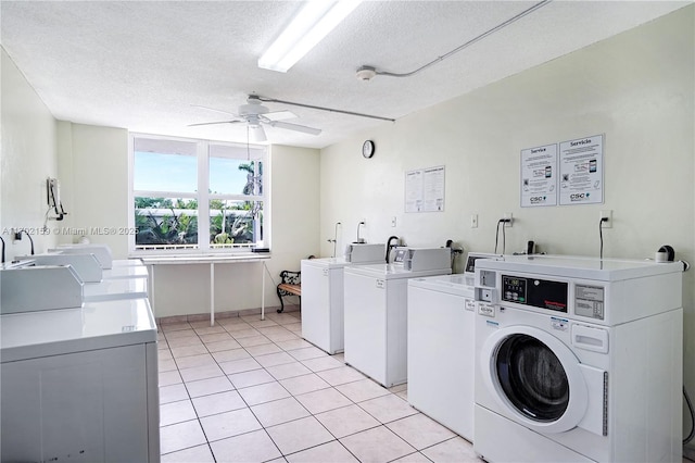 laundry room featuring sink, ceiling fan, washing machine and dryer, light tile patterned floors, and a textured ceiling