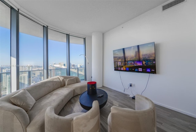 living room featuring expansive windows, hardwood / wood-style flooring, and plenty of natural light