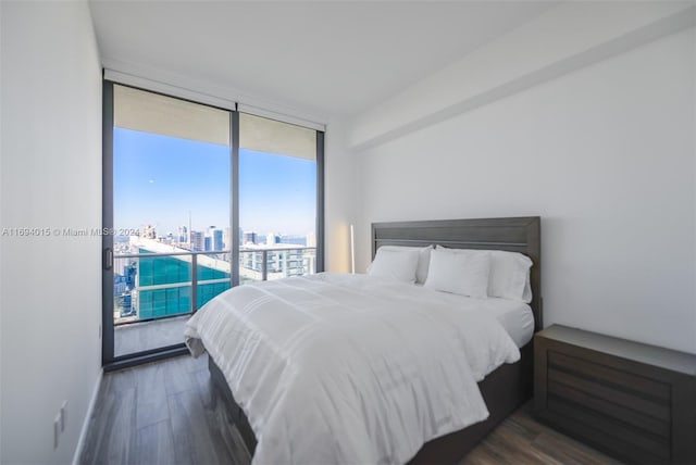 bedroom with access to outside, dark hardwood / wood-style floors, and floor to ceiling windows