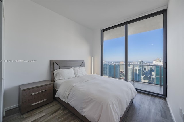 bedroom featuring floor to ceiling windows and dark hardwood / wood-style floors