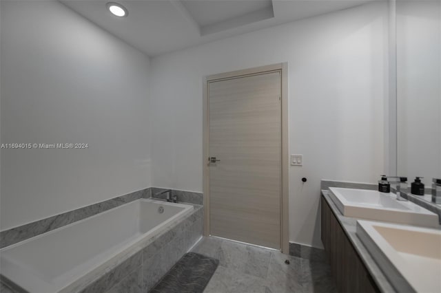 bathroom with tiled tub and vanity