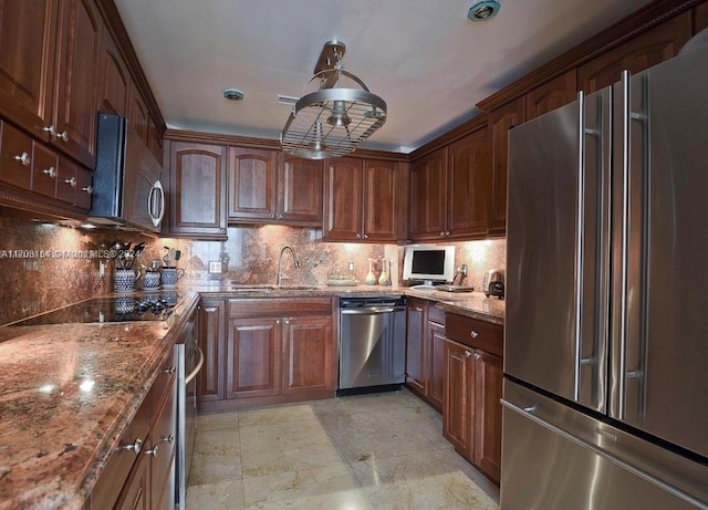 kitchen featuring pendant lighting, stainless steel appliances, tasteful backsplash, and stone countertops