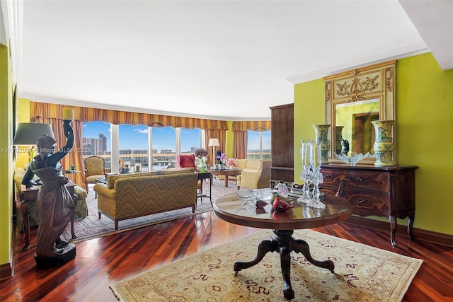 living room featuring ornamental molding, baseboards, a view of city, and wood finished floors