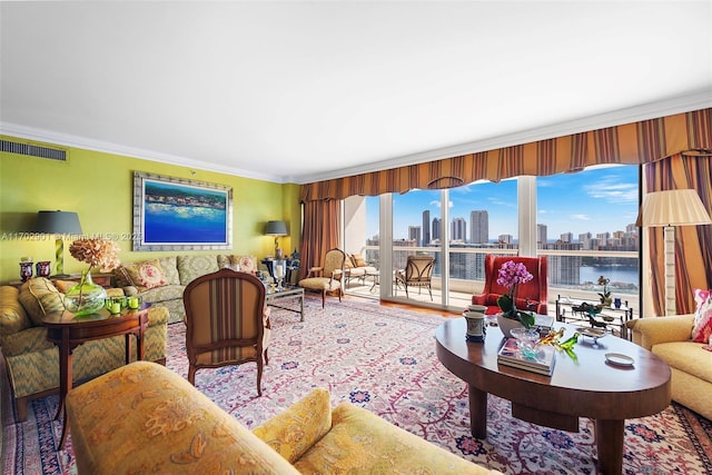 living area featuring a city view, visible vents, crown molding, and wood finished floors