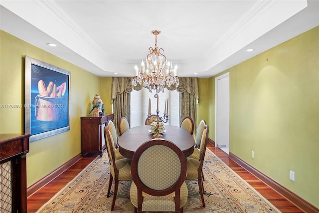 dining space featuring a raised ceiling, dark wood-type flooring, and an inviting chandelier