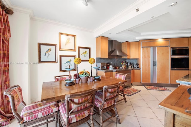 dining room with crown molding, light tile patterned floors, and a tray ceiling
