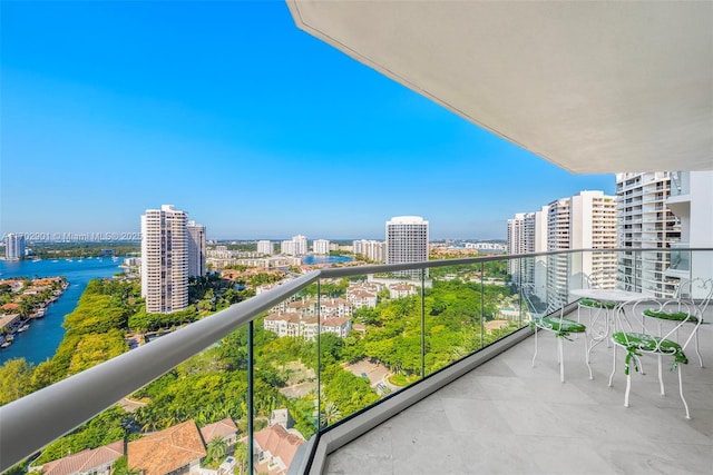 balcony featuring a water view and a city view