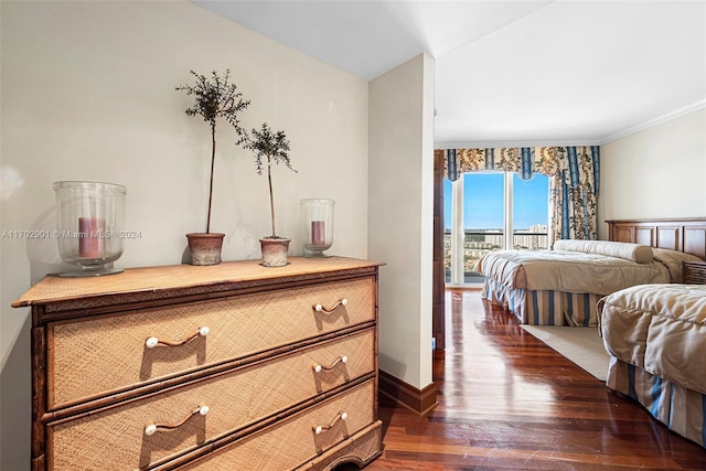 bedroom with dark hardwood / wood-style flooring, ornamental molding, and access to outside