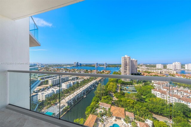 balcony featuring a water view and a city view
