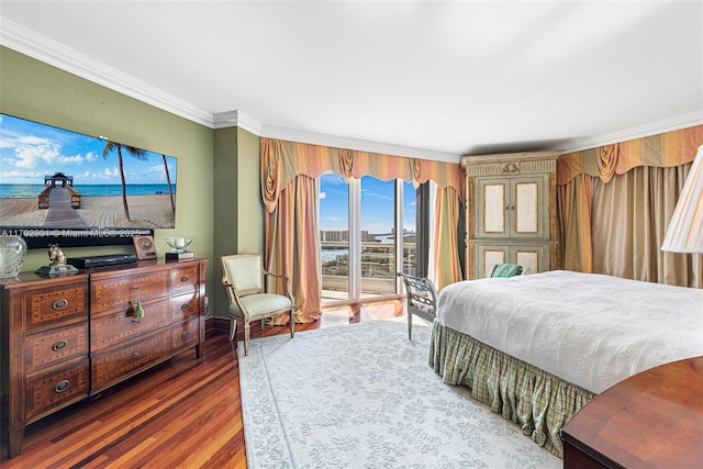 bedroom featuring access to exterior, ornamental molding, and wood finished floors