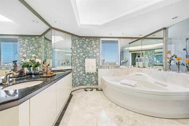 full bath with a sink, a bath, double vanity, and wallpapered walls