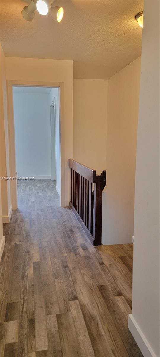 123 SW 113th Ave Unit 104-9, Sweetwater, FL 33174 - corridor featuring baseboards, wood finished floors, a textured ceiling, and an upstairs landing