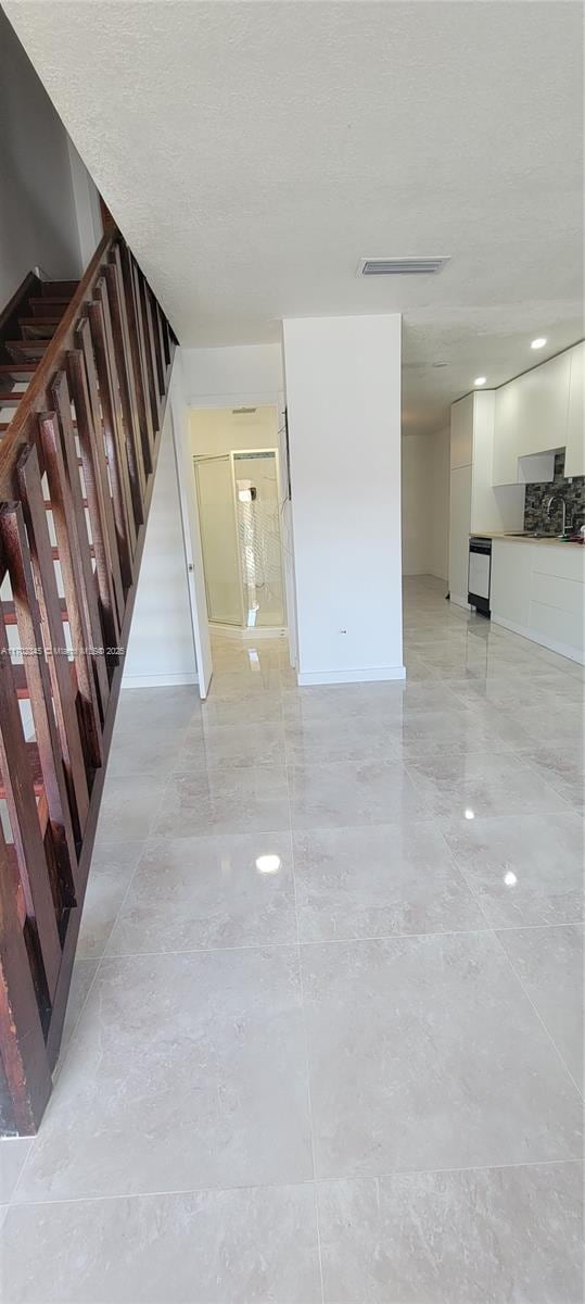 123 SW 113th Ave Unit 104-9, Sweetwater, FL 33174 - unfurnished living room featuring baseboards, stairway, and visible vents