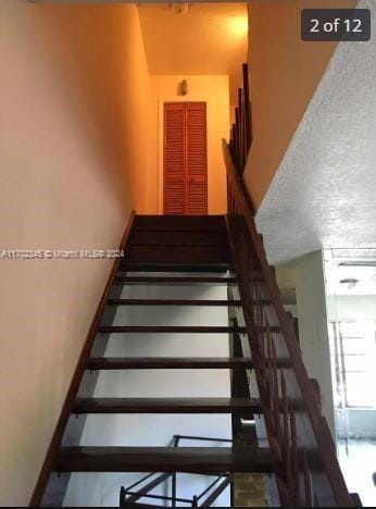 stairway with a textured ceiling