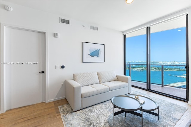 living room with hardwood / wood-style floors and a water view