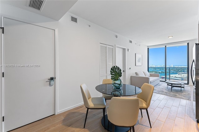 dining space with light wood-type flooring and floor to ceiling windows