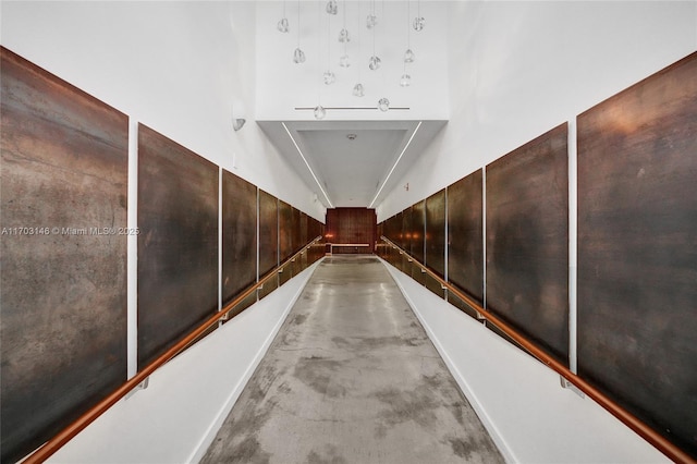 corridor with wood walls and concrete floors