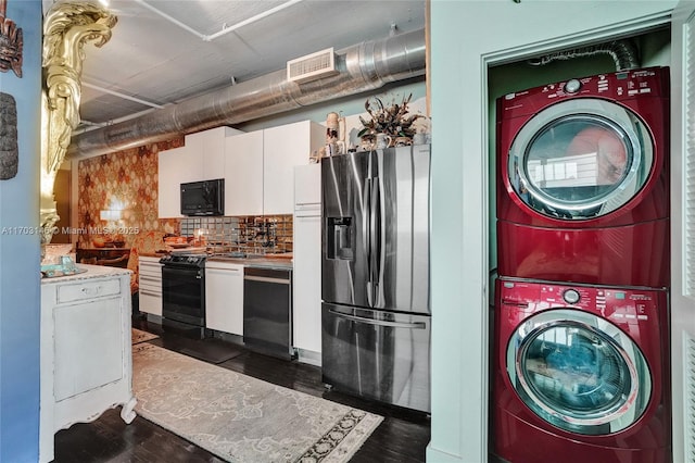 kitchen with decorative backsplash, white cabinetry, stacked washer and dryer, and black appliances