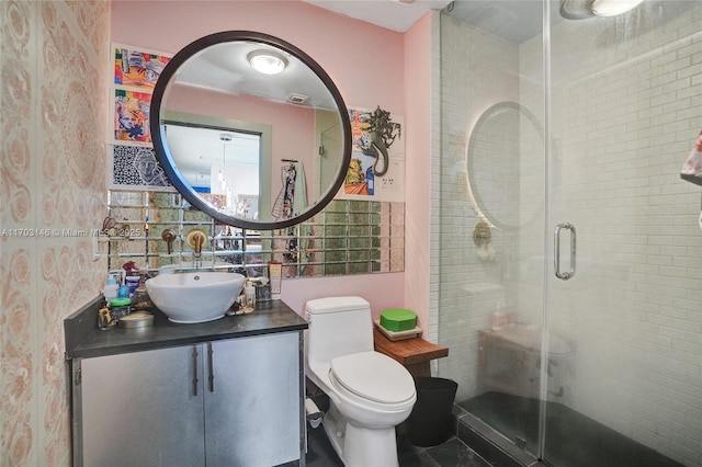 bathroom featuring vanity, toilet, and a shower with door