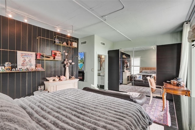 bedroom with a fireplace and track lighting