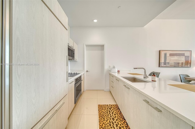 kitchen with sink, light tile patterned floors, and stainless steel appliances