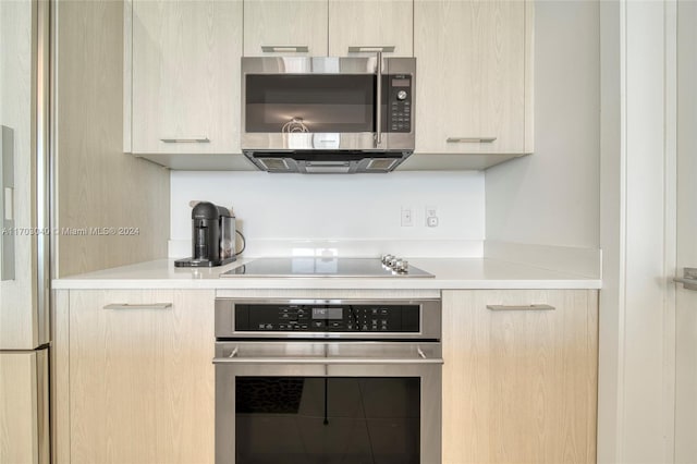 kitchen with appliances with stainless steel finishes and light brown cabinetry