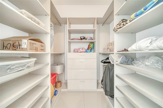 walk in closet with light tile patterned floors