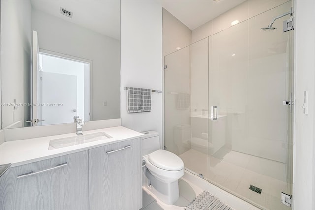 bathroom with toilet, vanity, tile patterned floors, and walk in shower