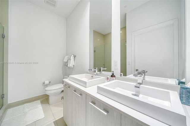 bathroom featuring tile patterned floors, vanity, toilet, and a shower with shower door