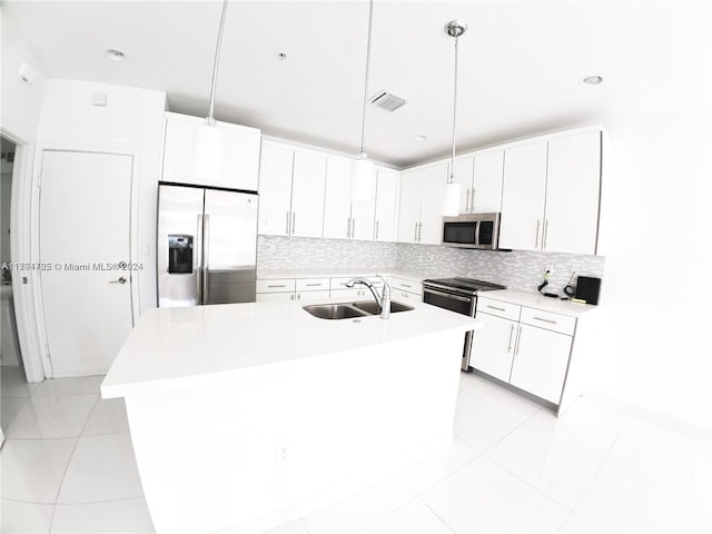 kitchen featuring decorative backsplash, stainless steel appliances, sink, decorative light fixtures, and white cabinetry