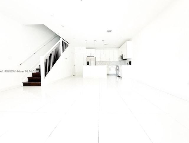 unfurnished living room featuring light tile patterned floors