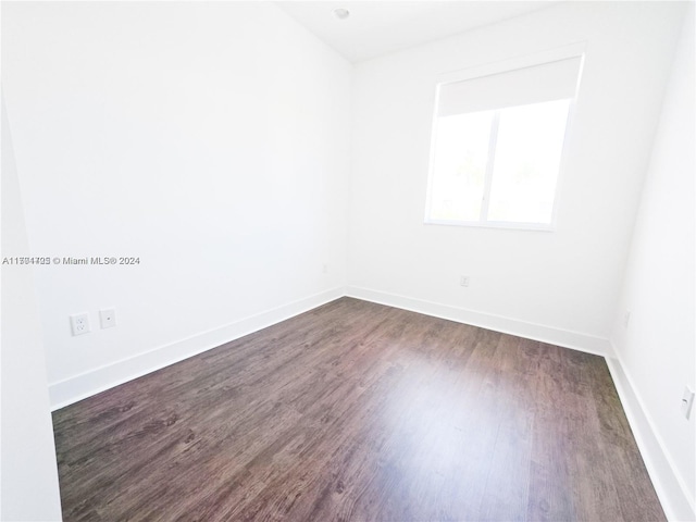 unfurnished room featuring dark wood-type flooring