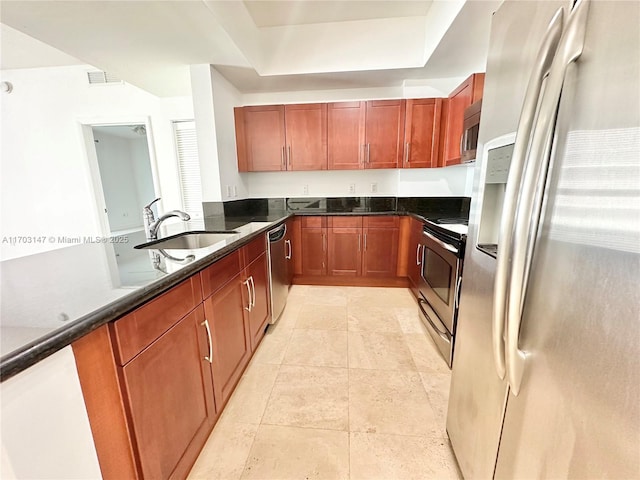 kitchen featuring light tile patterned flooring, stainless steel appliances, dark stone countertops, and sink