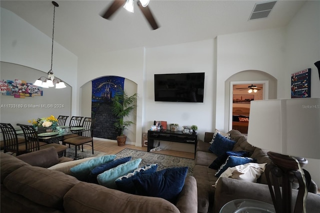 living room with hardwood / wood-style flooring, high vaulted ceiling, and a notable chandelier