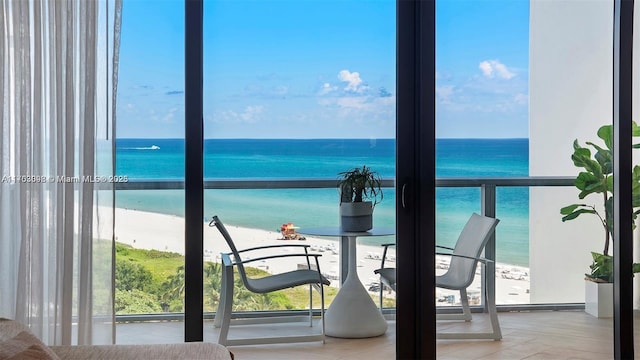 balcony featuring a water view and a beach view