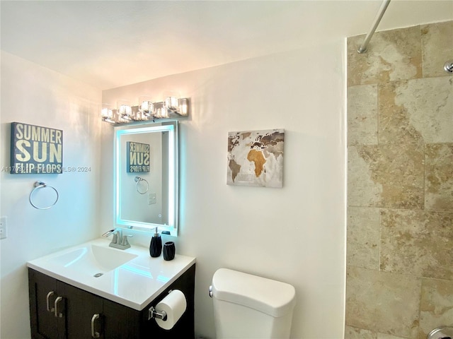 bathroom featuring vanity, toilet, and a tile shower