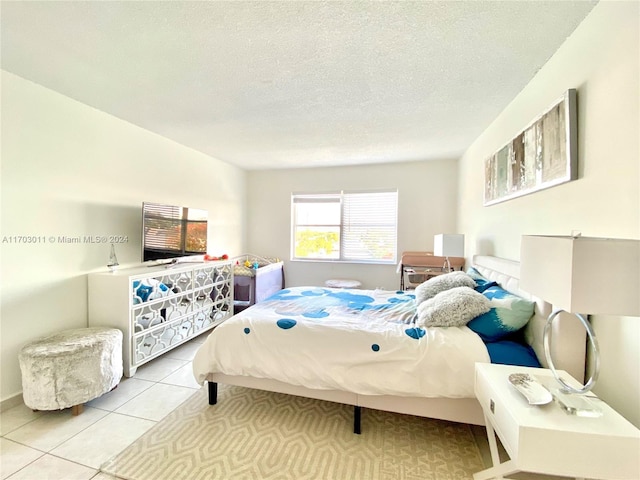 bedroom with light tile patterned floors and a textured ceiling