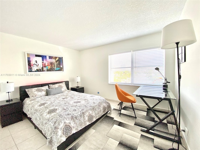 bedroom featuring light tile patterned floors and a textured ceiling