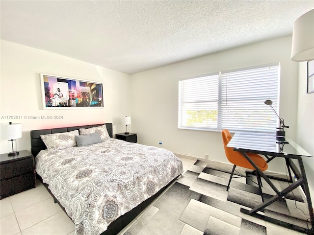 bedroom with light tile patterned floors and a textured ceiling