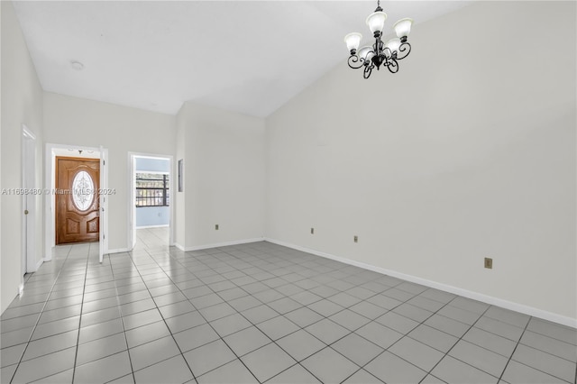 unfurnished living room featuring light tile patterned flooring, high vaulted ceiling, and a chandelier