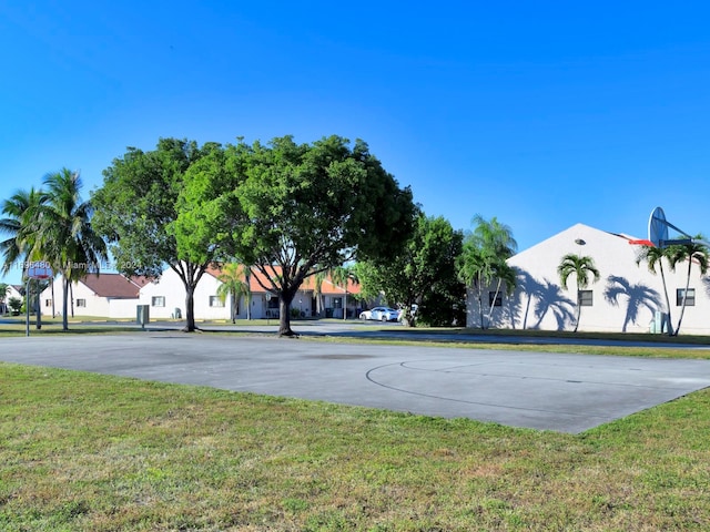 view of sport court with a yard