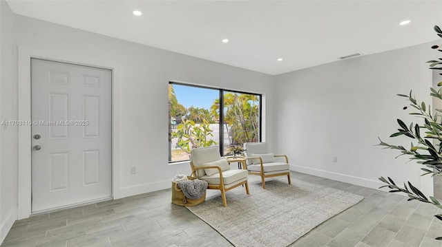 sitting room with wood finish floors, recessed lighting, visible vents, and baseboards