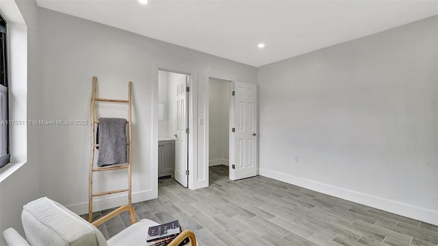 bedroom featuring light wood finished floors, recessed lighting, connected bathroom, and baseboards