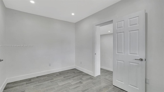 spare room with light wood-type flooring, baseboards, and recessed lighting