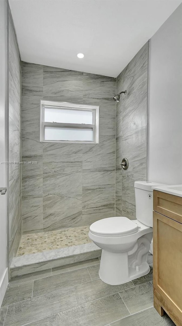 full bathroom featuring a shower stall, toilet, and vanity