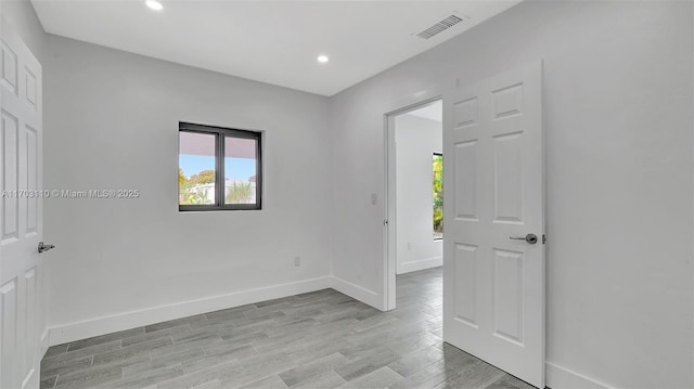 empty room with recessed lighting, baseboards, visible vents, and light wood finished floors