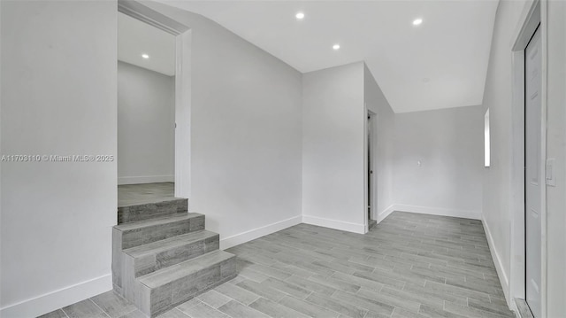 interior space with stairs, light wood-style floors, recessed lighting, and baseboards