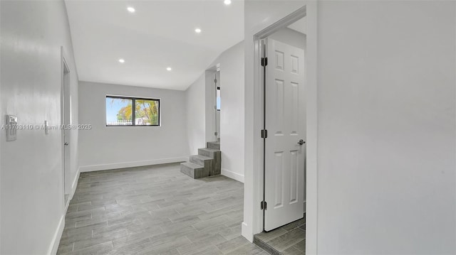 hallway with stairway, baseboards, and wood finish floors