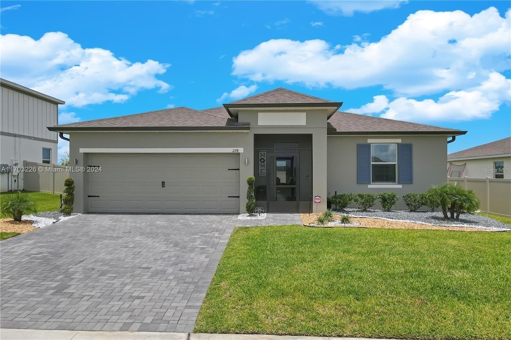 view of front of house with a front yard and a garage